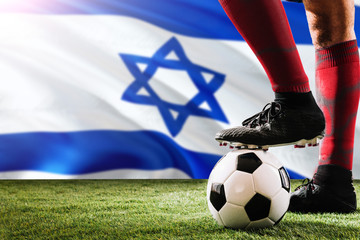 Close up legs of Israel football team player in red socks, shoes on soccer ball at the free kick or...