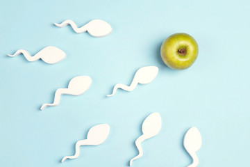 Sperm cells moving towards the green apple egg.