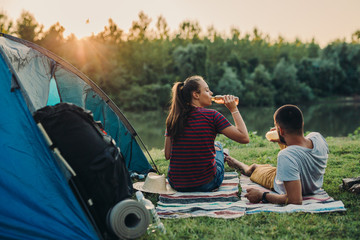 young couple relaxing by the river. camping outdoor