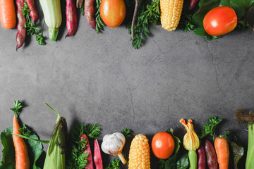 Healthy food clean eating selection. Corn, tomatoes, zucchini, carrot, beetroot, garlic, bean on a black background. Food concept. Flat lay, top view. Free space for your text.