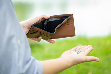 Closeup hand of asian businesswoman holding her wallet,hand open an empty wallet,spend money extravagantly,extravagant people never save money,poverty is a necessary consequence of extravagance