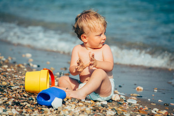 cute little boy playing on the beach outdoor