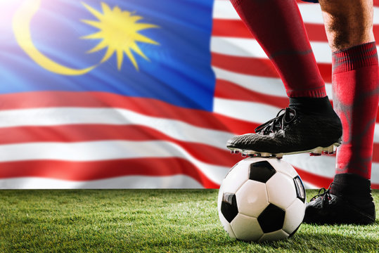 Close Up Legs Of Malaysia Football Team Player In Red Socks, Shoes On Soccer Ball At The Free Kick Or Penalty Spot Playing On Grass.