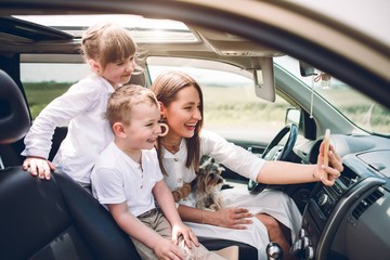 Mother with two children and a dog traveling by car