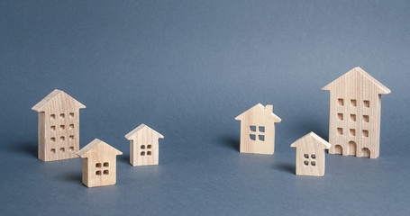 Wooden houses on a gray background. City, settlement. Buying a home. Real estate market. The concept of travel and choosing a new place of residence. Moving to another house. Search for options