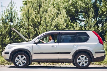 In a young beautiful woman's car was broken during the trip, she tries to call the tow truck