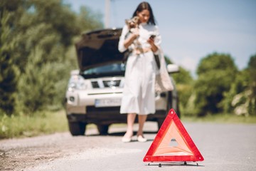 In a young beautiful woman's car was broken during the trip, she tries to call the tow truck