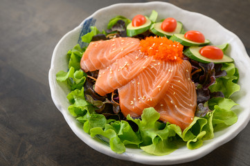 Raw Salmon sashimi with vegetable in ceramic bowl