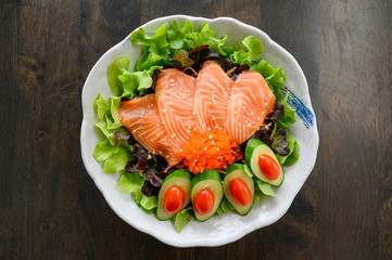 Raw Salmon sashimi with vegetable in ceramic bowl