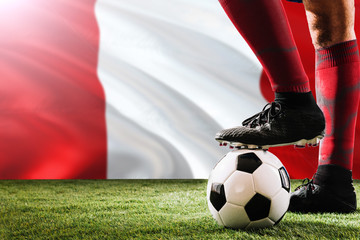 Close up legs of Peru football team player in red socks, shoes on soccer ball at the free kick or...