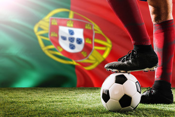 Close up legs of Portugal football team player in red socks, shoes on soccer ball at the free kick...