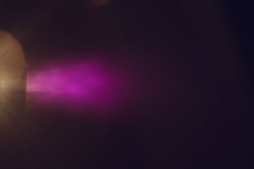 Haze purple light on dark abstract background. Defocused colored spotlight beam.