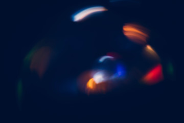 Multicolor bokeh lights. Blur glowing spots. Lens flare. Dark abstract background.