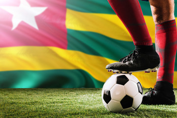 Close up legs of Togo football team player in red socks, shoes on soccer ball at the free kick or...