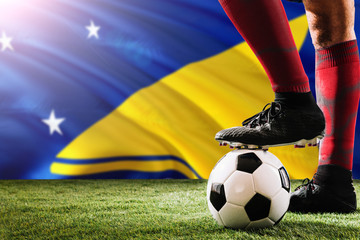 Close up legs of Tokelau football team player in red socks, shoes on soccer ball at the free kick...