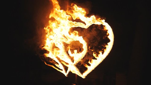 Two burning hearts on wedding fireshow. Slow motion.