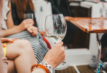 The woman holds glass with old red wine at party.