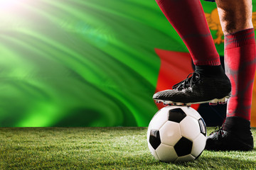 Close up legs of Zambia football team player in red socks, shoes on soccer ball at the free kick or...