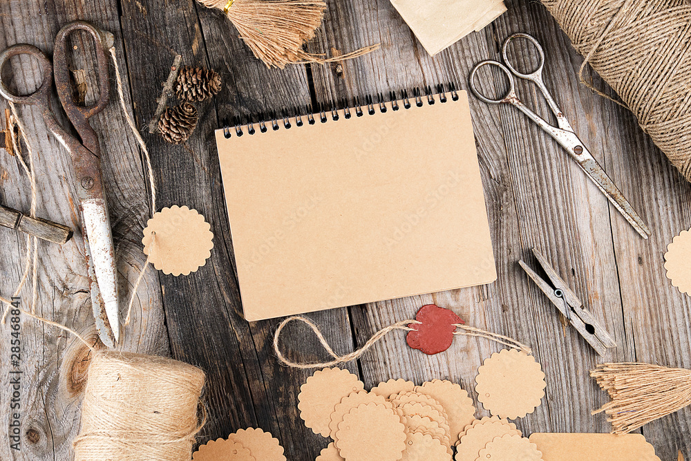 Poster notepad with brown empty sheets on a gray wooden table, next to it are a rope