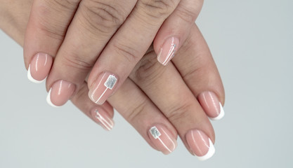 French nails manicure on girl hands.Modern manicure with geometric shapes. Close up, selective...