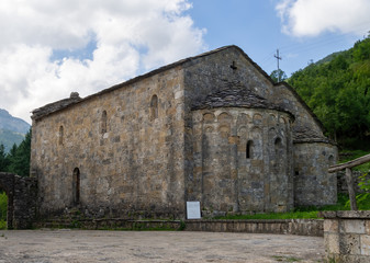 Fototapeta na wymiar Ancient church in Vagli Sotto, in Garfagnana, Italy, here seen from the rear. Dedicated to St Augustine it dates back to the 11th century.