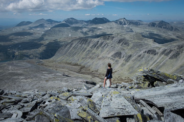 Woman standing on rocky top of Storronden, Rondane National Park, Norway