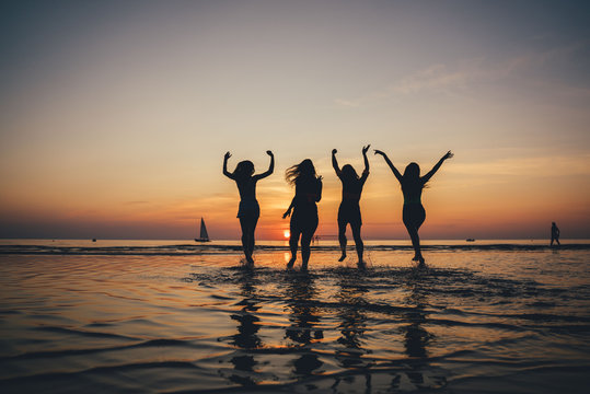 Beautiful party girls silhouette on sea. Happy people.