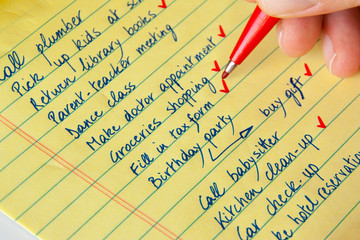 Close-up of a handwritten to do list and pen.