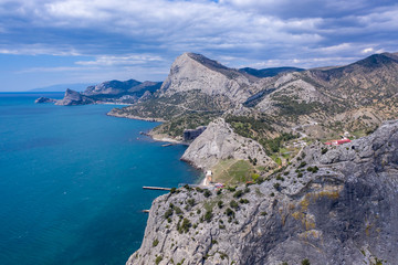 Fototapeta na wymiar Panoramic view towards Green bay of Novy Svet (New World) location from top of Koba-Kaya Mountain, Sudak area, Crimea. Aerial drone view