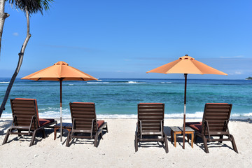 Tropical beach resort with lounge chairs and umbrellas on the sandy beach of Gili Meno Island, Indonesia