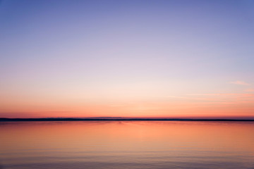 Fototapeta na wymiar Soft dawn over the sea surface before the sun appears over the horizon on the White sea