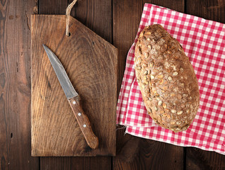 oval bread made from rye flour with pumpkin seeds on a red napkin