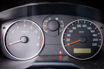 close-up of dashboard with speedometer and tachometer in a car