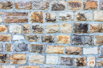 A very old wall made of natural stone, texture of stone.