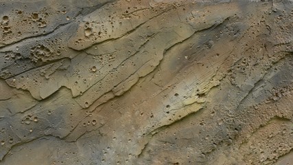 The rough surface of the cement wall with beautiful patterns and colors looks like art.