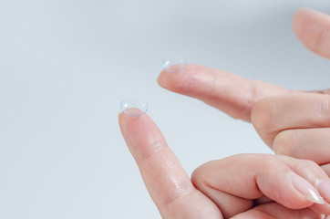 Contact lens close-up on a woman’s fingertip.