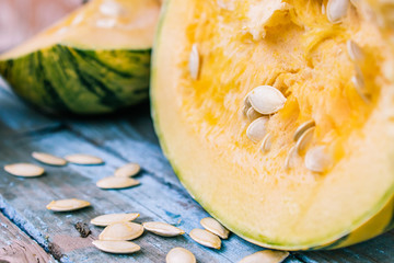 Closeup of a pumpkin with seeds on dark blue old boards.