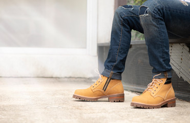 The men model wearing jeans and yellow boots leather with zipper for man collection.