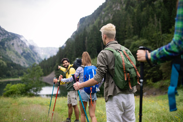Smiling friends walking with backpacks. Adventure, travel, tourism, hike and people concept.