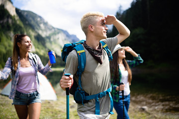 Naklejka premium Group of happy friends with backpacks hiking together