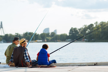 Boy feeling memorable while fishing with dad and granddad