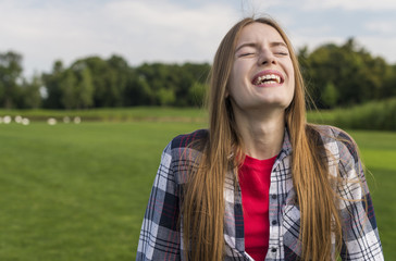 Fototapeta premium Blonde girl laughing with her eyes closed