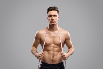 Muscular guy with tape measure
