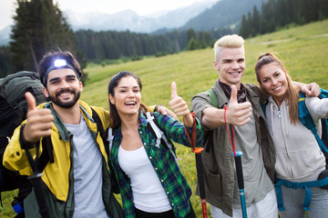 Group of friends are hiking in mountain. Young people walking through countryside.