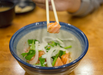 Chopsticks with Raw Salmon Sashimi, focus selective