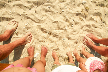 Fototapeta na wymiar Family feet on the sand on the beach
