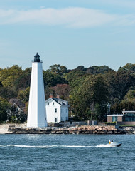 NEw London Lighthouse with small boat moving past