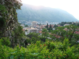 Obraz premium Panorama of the modern areas of Kotor from the top of the cliff against the backdrop of the bay and the mountain ridge on the horizon.