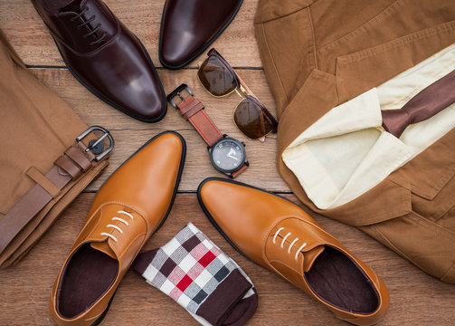Men fashion casual clothing set and accessories isolated on wooden background include oxford shoes, yellow suit, pants, belt, sunglass, sock and office shirt. Flat lay, top view