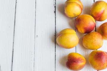 Delicious and juicy peach (nectarina) on white wooden table